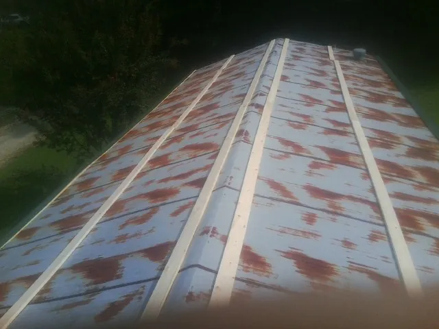 Rusted metal roof panels with new wood purlins before replacement — Storm Damage Roof Repair in Dowling by Roofing Brothers
