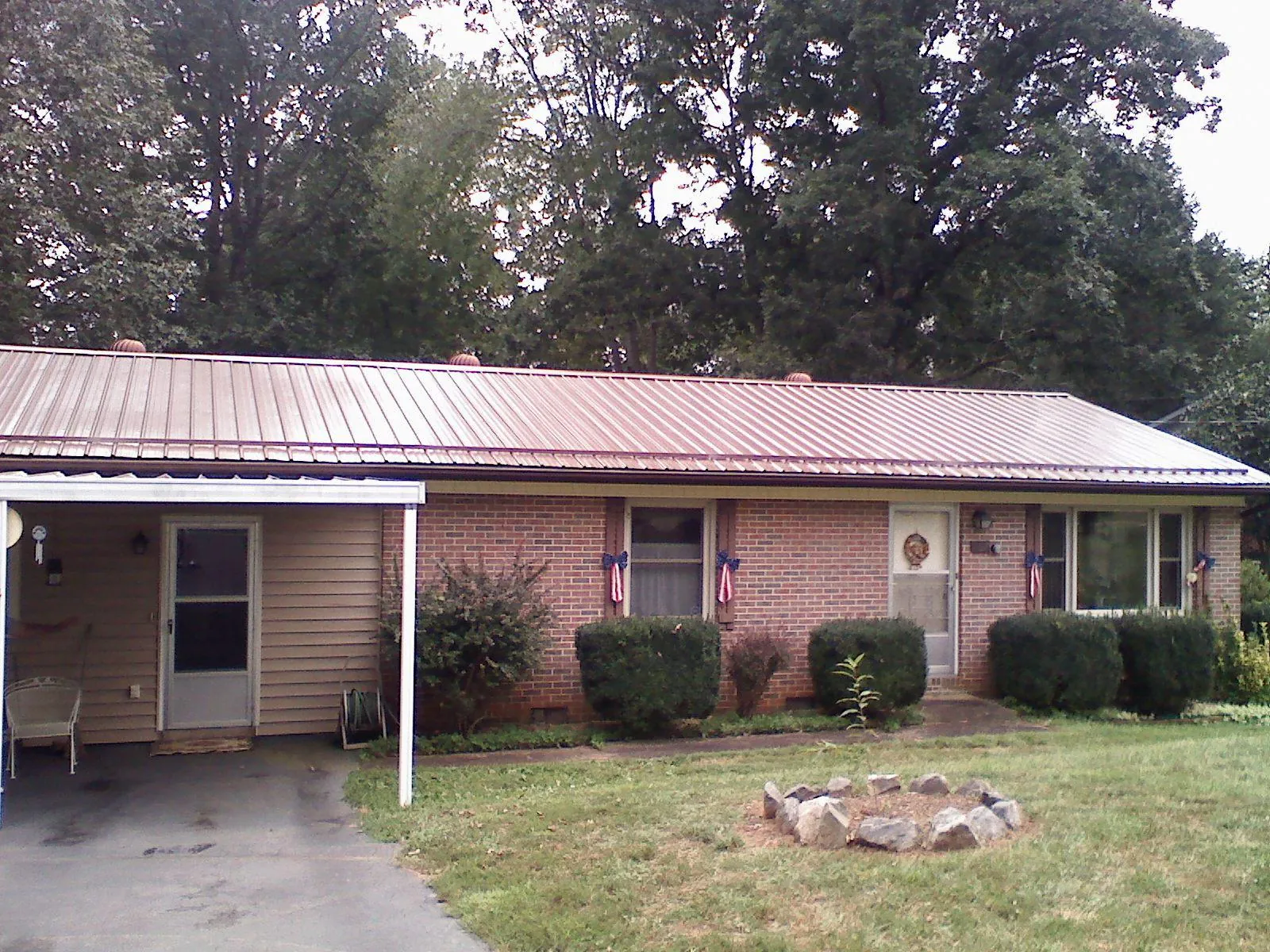 Bronze metal roof and carport on a brick ranch home — Roof Repair work by our crew in Dowling